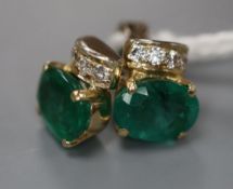 A modern pair of 750 yellow metal, oval cut emerald and four stone diamond set ear studs, 9mm, gross