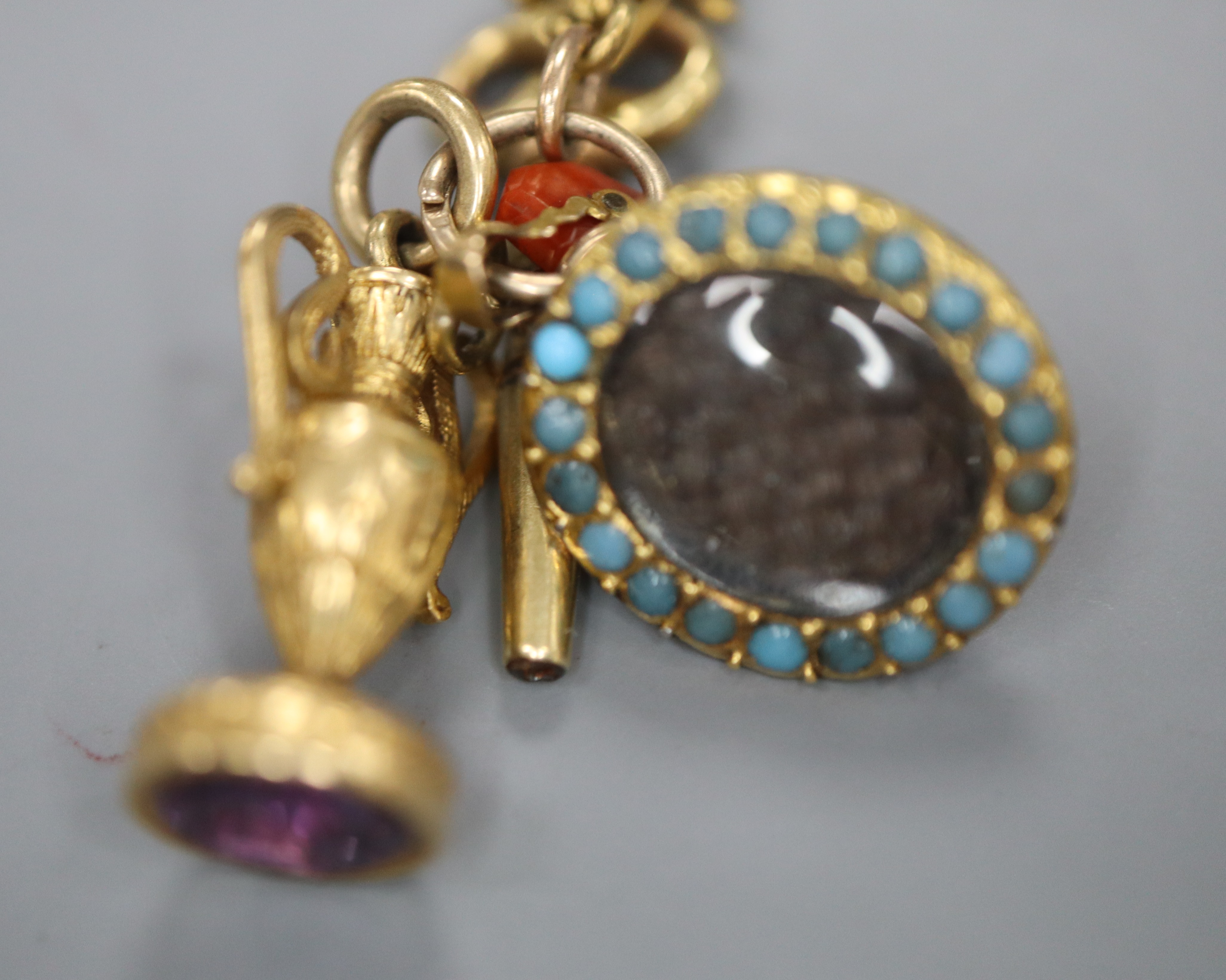 A group of four assorted charms on a yellow metal small chain, including a watch key and small - Image 2 of 2