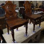 A pair of Victorian carved mahogany hall chairs