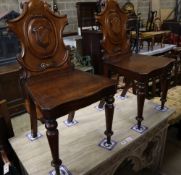 A pair of Victorian carved mahogany hall chairs