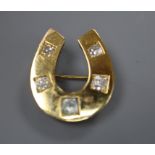 A yellow metal and five stone round cut diamond set horseshoe pendant brooch, 26mm, gross 8.8