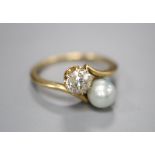 A yellow metal, diamond and cultured pearl set two stone crossover ring, size H/I, gross 2.4 grams.