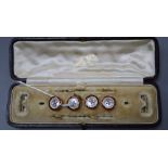 Four early 20th century cased 9ct, mother of pearl and enamel buttons.