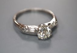 A modern white metal (stamped iridium and plat) and single stone diamond ring, with baguette and