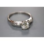 A modern white metal (stamped iridium and plat) and single stone diamond ring, with baguette and