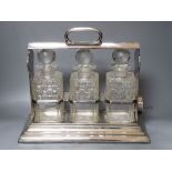 A silver plate three bottle tantalus, width 38cmCONDITION: Two decanters each with a chip to the