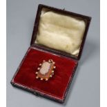 A yellow metal and sardonyx cameo hardstone and seed pearl set pendant brooch, carved with the