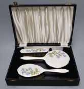 A three piece silver plated translucent enamelled dressing table set, cased