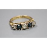 An early 20th century 18ct gold three stone diamond and two stone sapphire set half hoop ring,