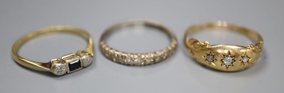 Three assorted 18ct and gem set rings including diamond half eternity, size N, and three stone