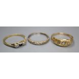 Three assorted 18ct and gem set rings including diamond half eternity, size N, and three stone