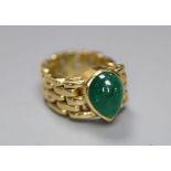 A yellow metal and solitaire pear shaped cabochon emerald set ring, with articulated shank, size G/