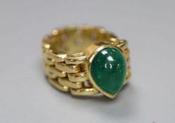 A yellow metal and solitaire pear shaped cabochon emerald set ring, with articulated shank, size G/