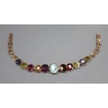 An early 20th century yellow metal and graduated multi gem stone set bracelet, including amethyst,