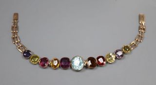 An early 20th century yellow metal and graduated multi gem stone set bracelet, including amethyst,