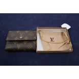 A Louis Vuitton purse, with pouch and box.