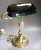 A brass desk lamp with green glass shade