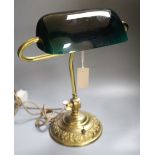 A brass desk lamp with green glass shade