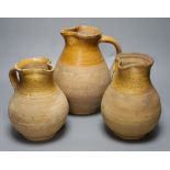 A group of three late 19th century part glazed Verwood pottery pitchers, tallest 25cm