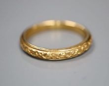 A late Victorian carved 22ct gold wedding band, size N/O, 5.1 grams.