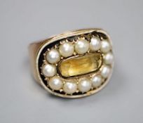 A George III yellow metal, black enamel, split pearl and foil backed citrine set oval mourning ring,