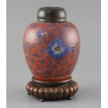 A Chinese coral red ground underglaze blue jar, Kangxi period, painted with flowerheads and