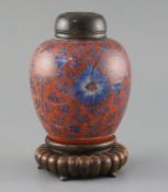 A Chinese coral red ground underglaze blue jar, Kangxi period, painted with flowerheads and