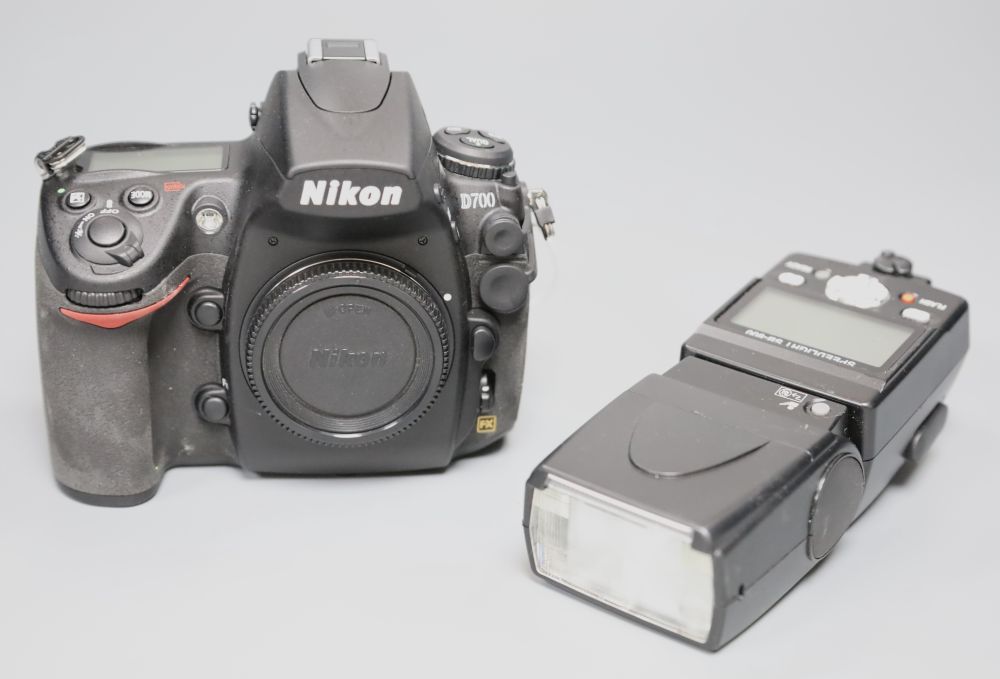 A Nikon D700 SLR camera body with a Nikon flash gun