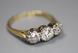 An 18ct and plat set three stone diamond ring, size M/N, gross 2.8 grams, the largest approx. 5mm in