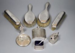 A George V engine turned silver hip flask, four silver mounted brushes, three piece condiment set