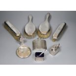 A George V engine turned silver hip flask, four silver mounted brushes, three piece condiment set