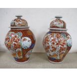 A near pair of Japanese porcelain lidded vases together with a blue and white vase and a