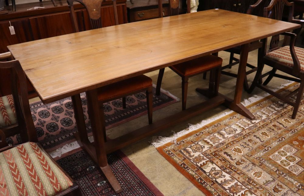 A Gordon Russell walnut dining table, circa 1930, on chamfered double end supports and central