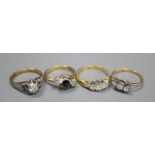 Four assorted 18ct and gem set rings, including two three stone diamond rings, a single tone diamond