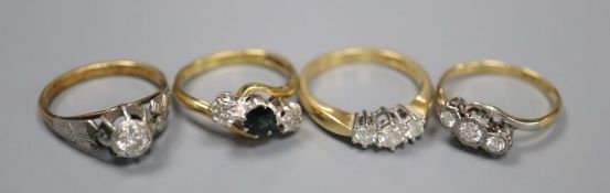 Four assorted 18ct and gem set rings, including two three stone diamond rings, a single tone diamond