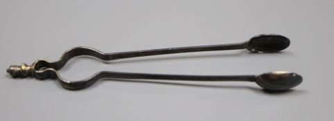 A pair of antique white metal sugar tongs in the form of fire tongs, indistinct marks, 12.4cm, 14