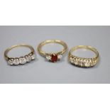 An 18ct gold, garnet? and diamond three stone ring and two yellow metal and five stone diamond