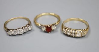 An 18ct gold, garnet? and diamond three stone ring and two yellow metal and five stone diamond