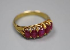 A yellow metal and graduated five stone ruby set half hoop ring, three stone a.f., size M, gross 3.4