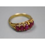 A yellow metal and graduated five stone ruby set half hoop ring, three stone a.f., size M, gross 3.4