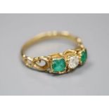 A Victorian style yellow metal (stamped 18ct), two stone emerald and single stone diamond set