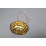 A Victorian yellow metal and diamond set oval brooch, with glazed back and safety chain, 39mm, gross