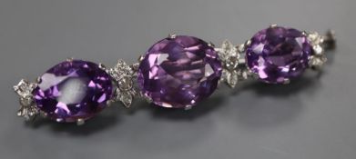 A modern white metal, three stone oval cut amethyst and diamond chip set bar brooch, 55mm, gross