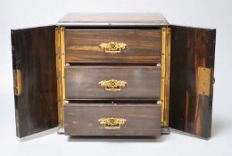 A Victorian coromandel cabinet with three drawers and two doors, with key, 22cm wide