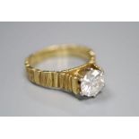 A modern textured 18ct gold and solitaire diamond ring, the stone weighing 0.90ct, size L, gross 4.1