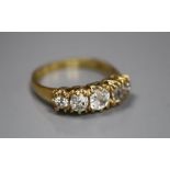 An 18k yellow metal and graduated five stone diamond set half hoop ring, size O, gross 3.8 grams,