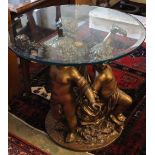 A cast gilt metal glass top cherub centre table, 81cm diameter