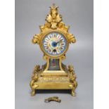 A 19th century French gilt metal mantel timepiece, with ceramic dial, pendulum and key, 31cm