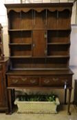 An 18th century oak low dresser with later boarded plate rack, width 128cm depth 46cm height 216cm