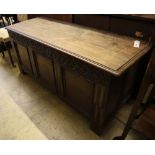 A 17th/18th century inlaid oak coffer with panelled front and planked top, width 145cm depth 53cm